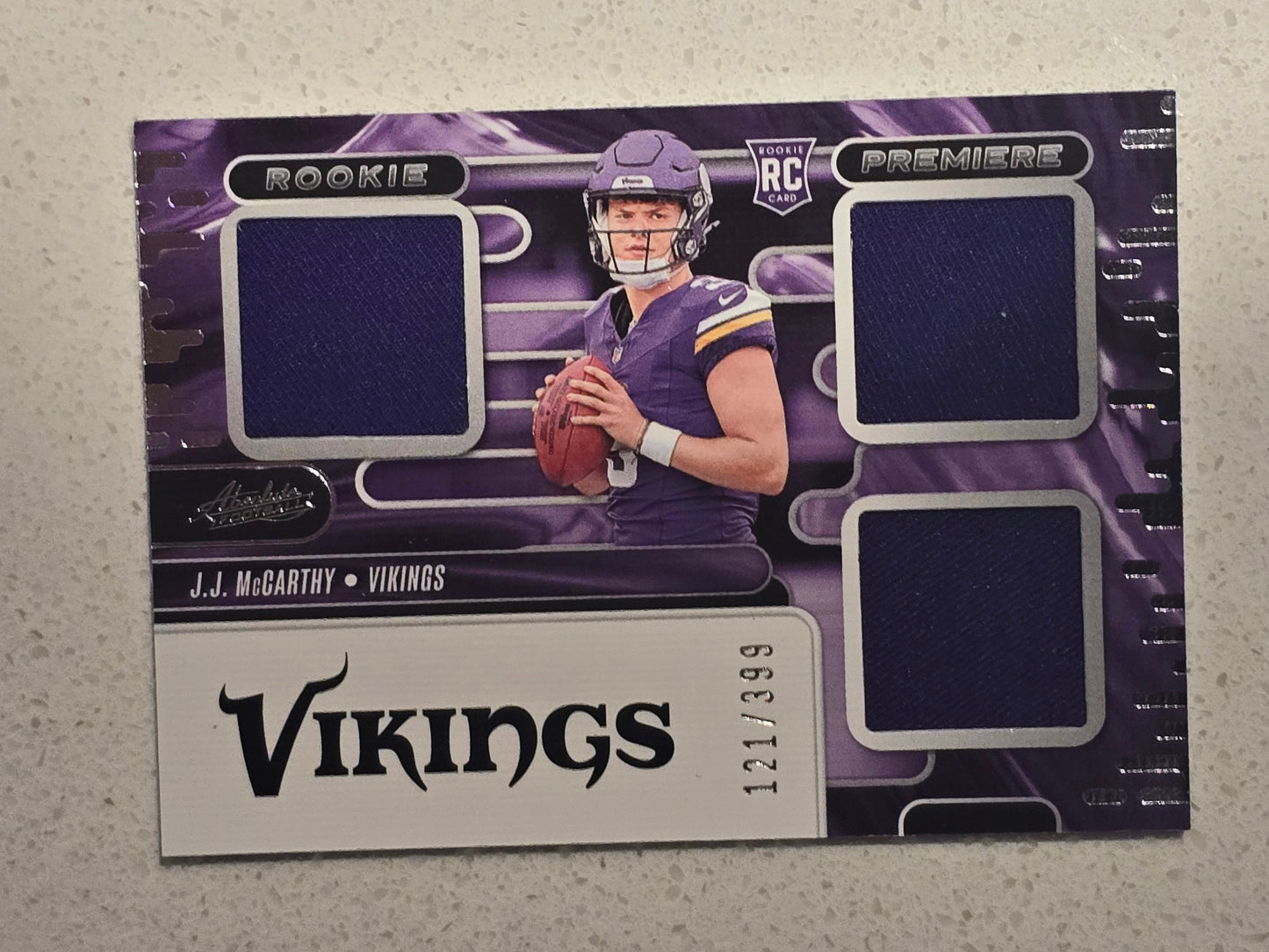 J.J. McCarthy 2024 Panini Absolute Rookie Premiere Triple Memorabilia Card